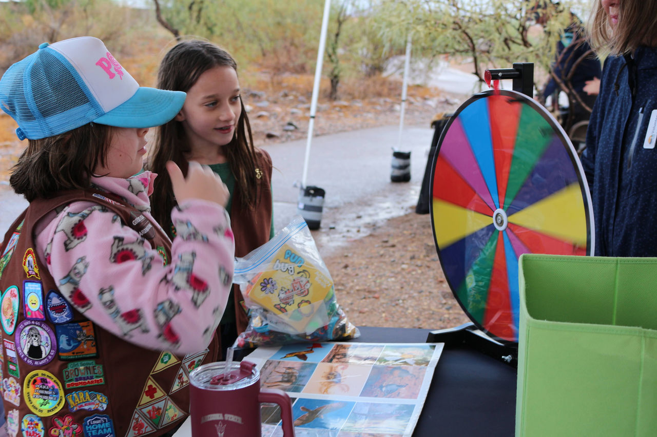 two girls spinning a wheel of prizes on a table