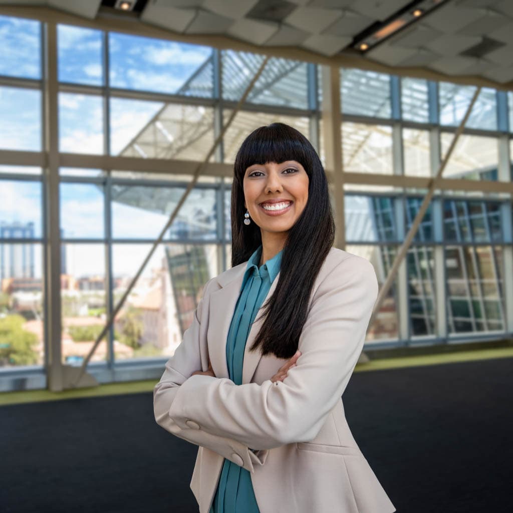 Woman in a suit jacket with a glass and steel background