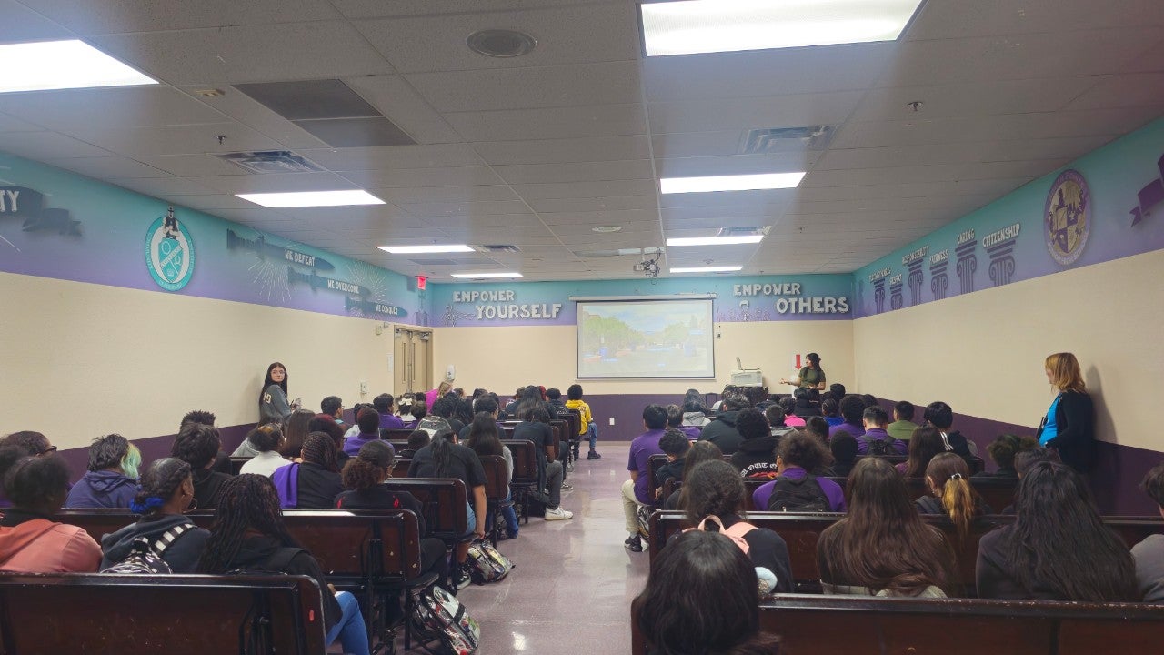 A Phoenix employee gives a presentation at a school.