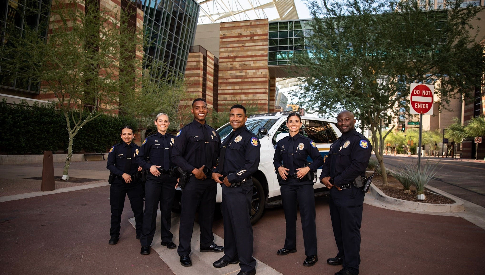 A group of five Phoenix police officers pose outside.