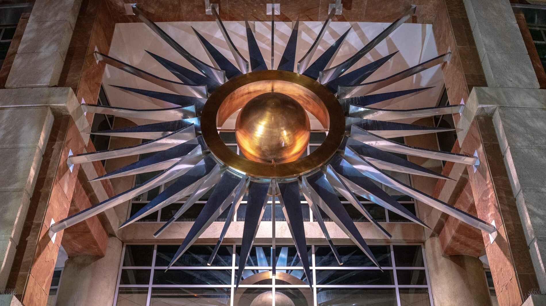A sculpture of a sunburst hanging in city hall.