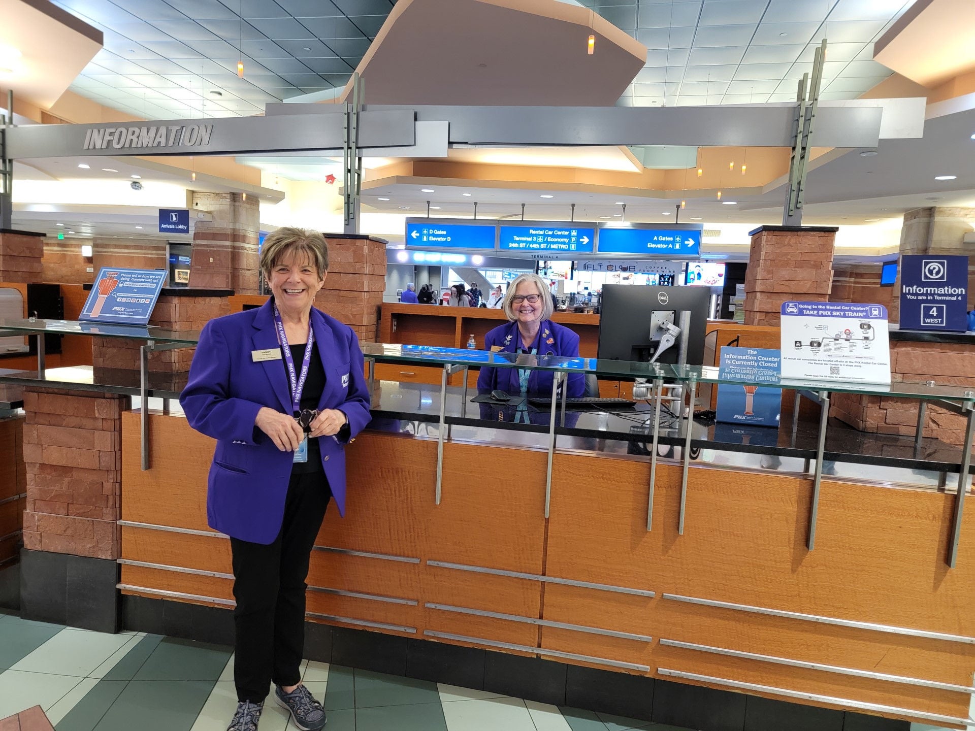 two navigators at information desk smiling