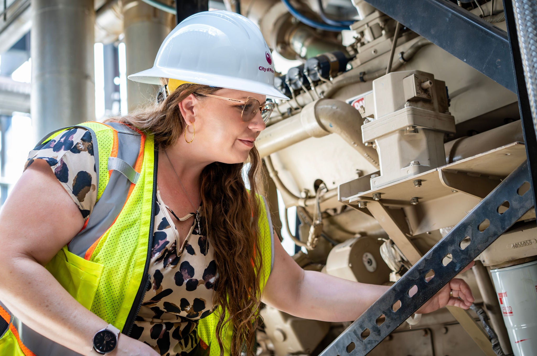 A Public Works employee checks an HVAC system for regulatory compliance