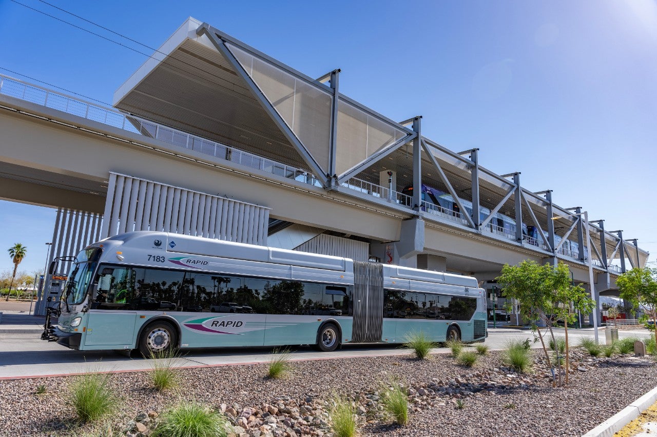 <p>A Phoenix RAPID bus parked at the Thelda Williams Transit Center. The Metro Parkway elevated light rail station can be seen above the bus. </p>