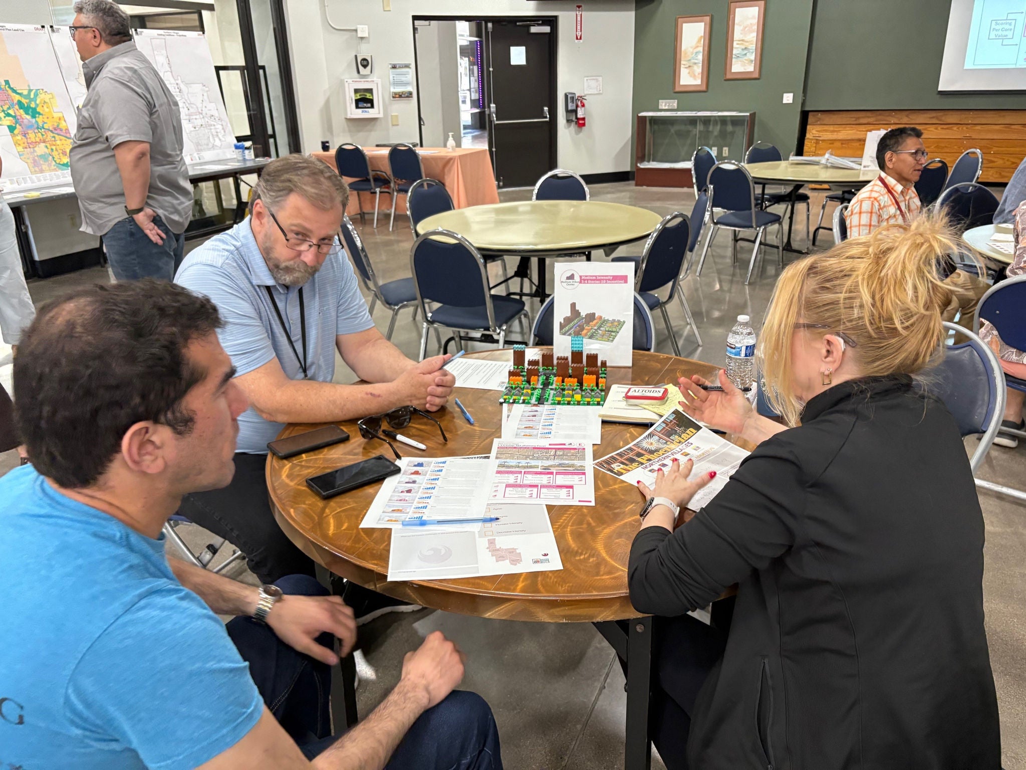 Image shows 3 people, 2 males and 1 female discussing the display of a medium intensity district