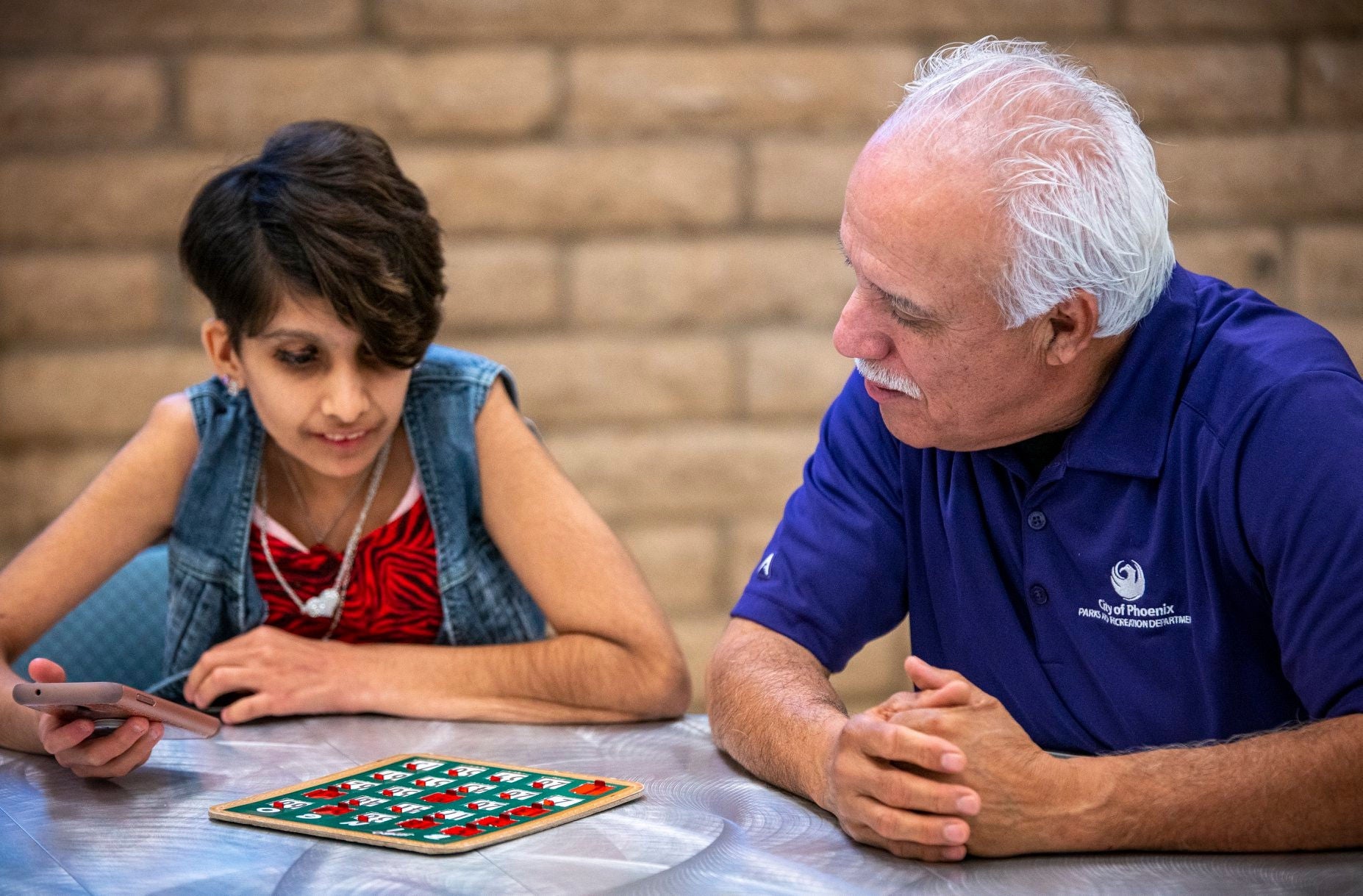 Two individuals play bingo together.