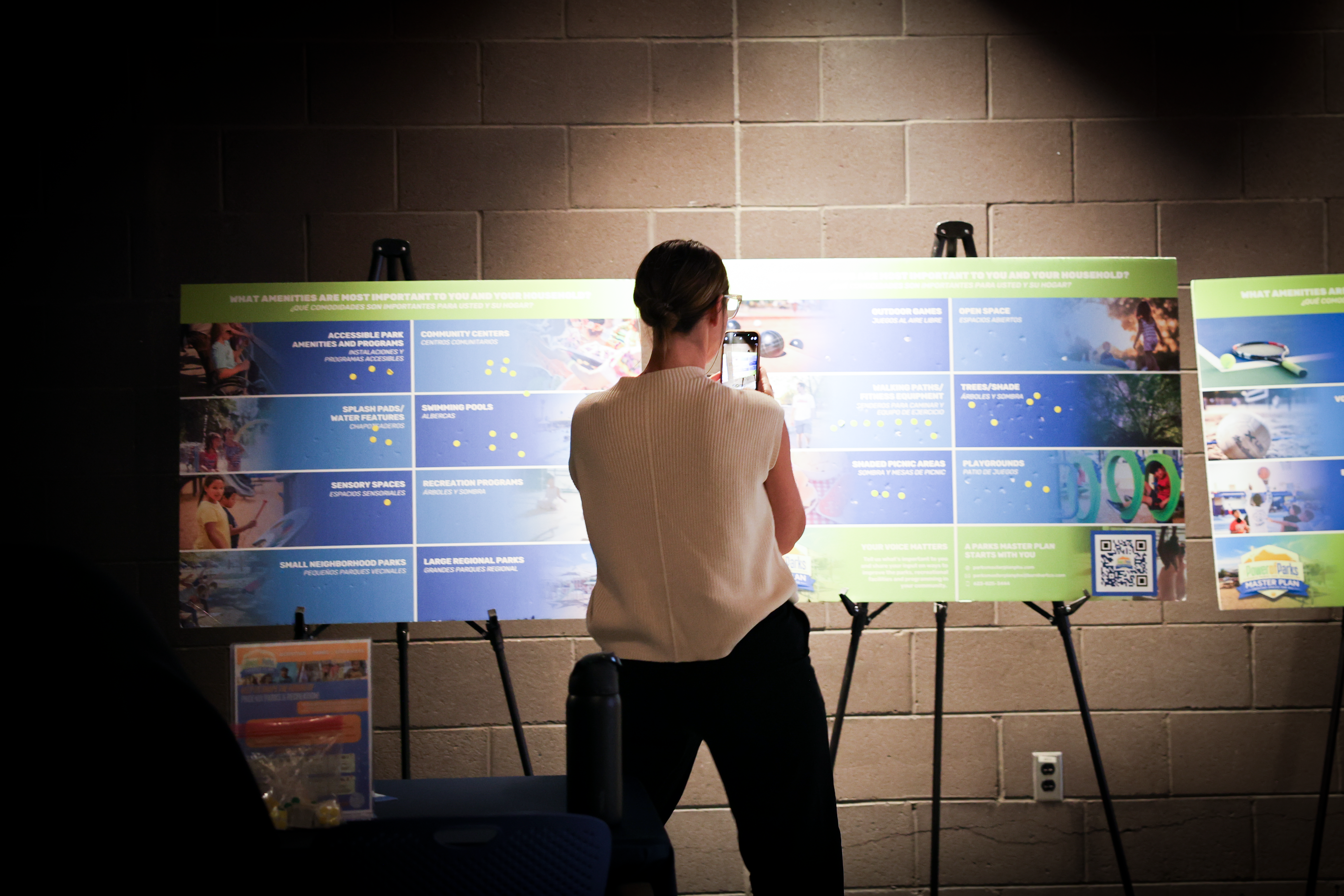 Woman taking photos of Parks Master Plan posters 