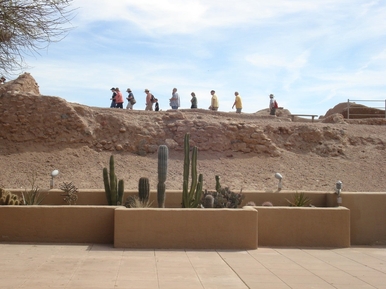 A group of tourists walk through the outdoor museum site.