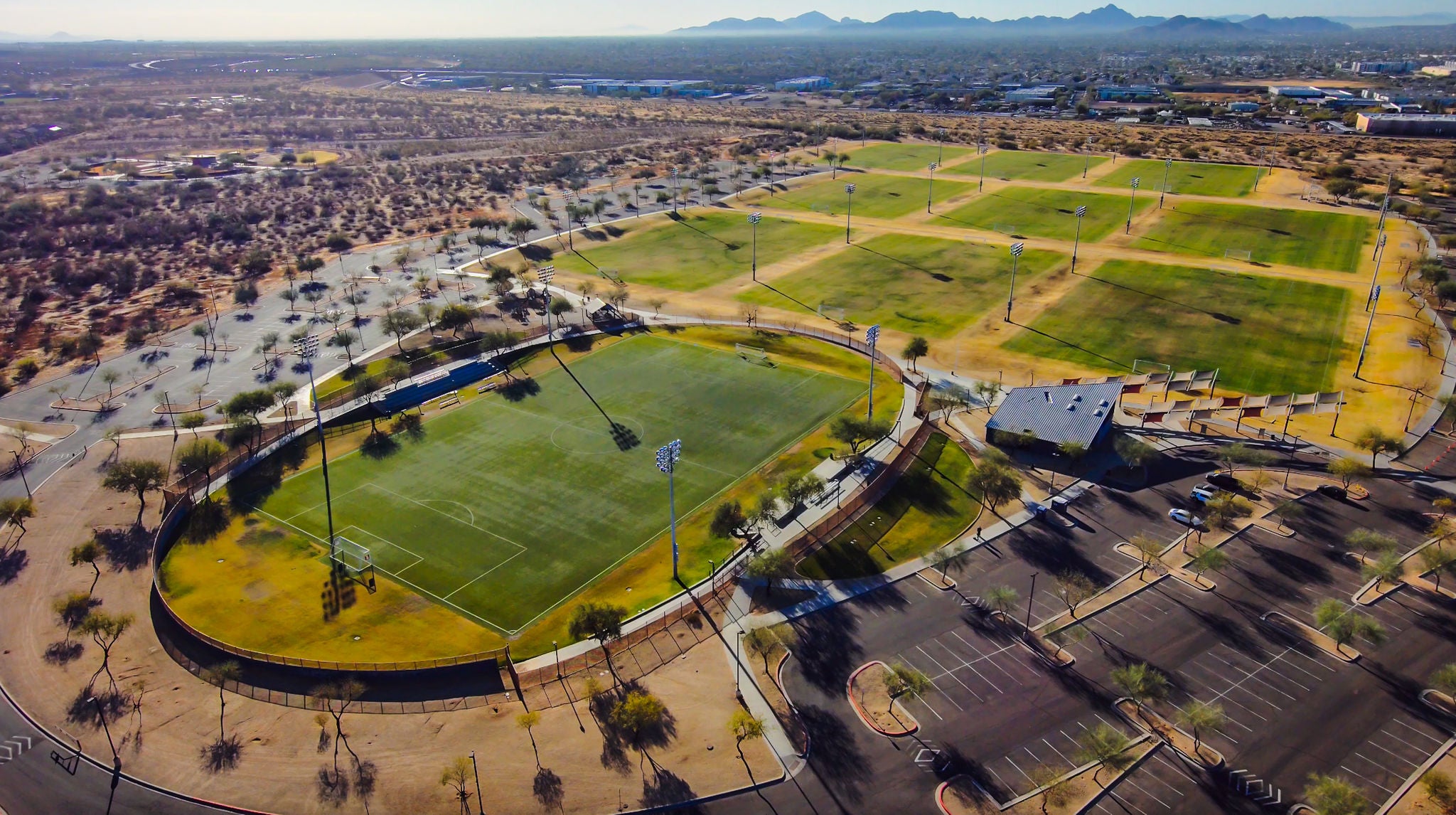 Aerial shot of sports fields, a parking lot, and trees and other plants at Reach 11 Recreation Area.