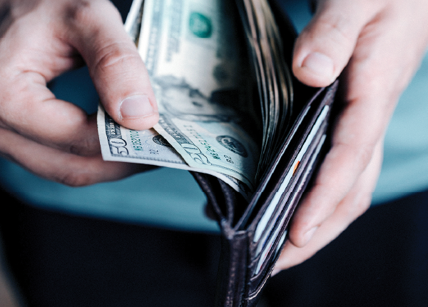 Hands pulling money out of a wallet to pay a water bill