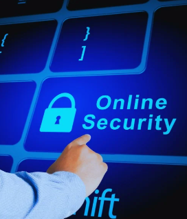 A close-up of a computer keyboard shows that the "Enter" key has been changed. Instead of its usual label, it now says, "Online Security" and has a small padlock icon, symbolizing digital safety. A man's right hand, wearing a blue shirt, is pointing at the word "Security," emphasizing the importance of online protection.