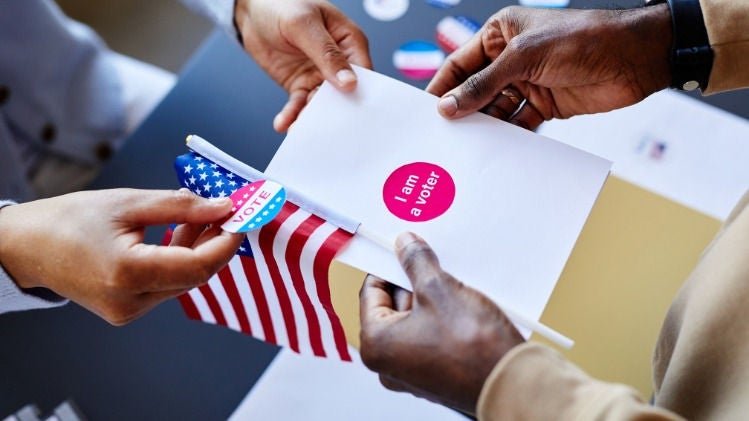 Picture of someone being handed a ballot and "I voted today" sticker