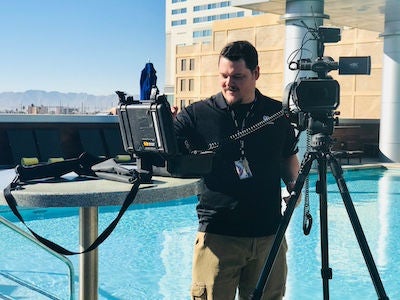 Jason Ingersoll works with his film equipment as he records outside on a bright day.