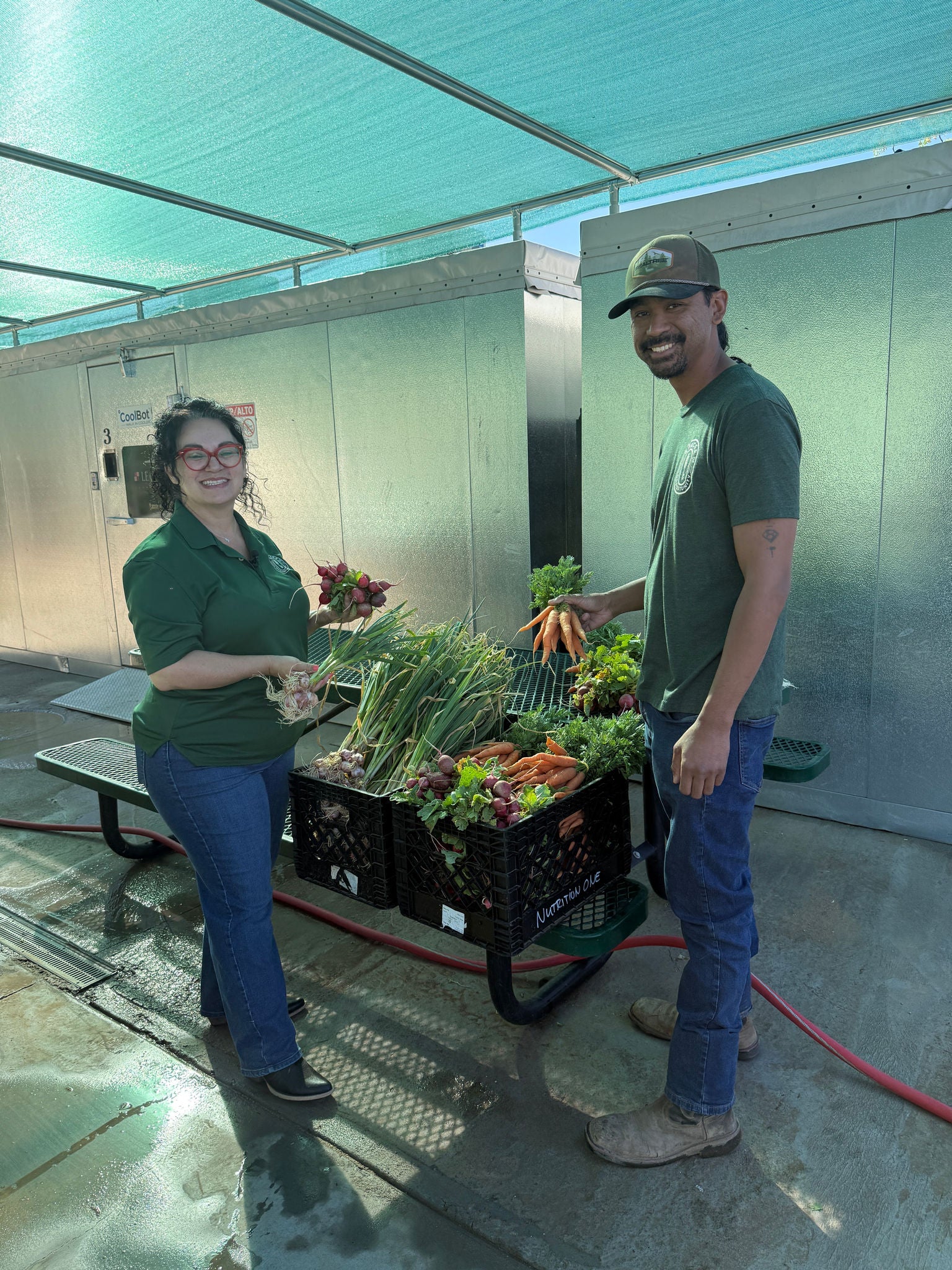 Maria Valenzuela and Sowan Thai stand in front of the refrigeration units at Spaces of Opportunity.