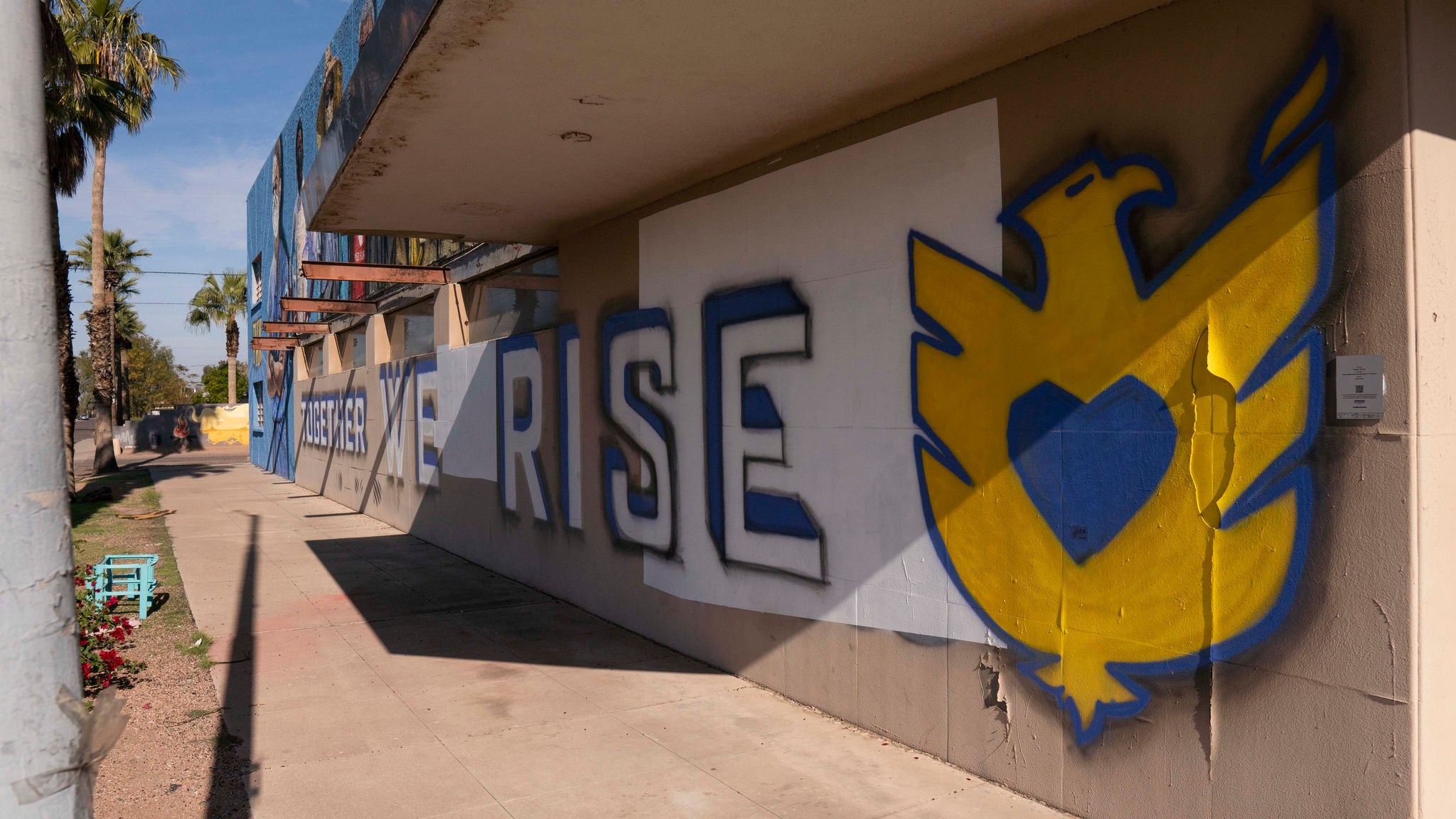 A mural that reads, "We rise."