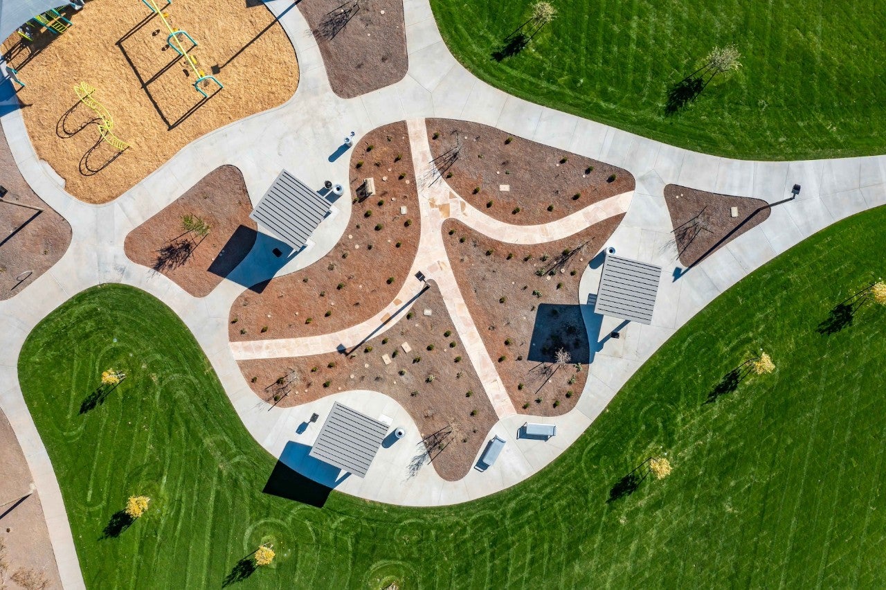 Arial photograph of a playground, surrounded by sidewalks and grass.