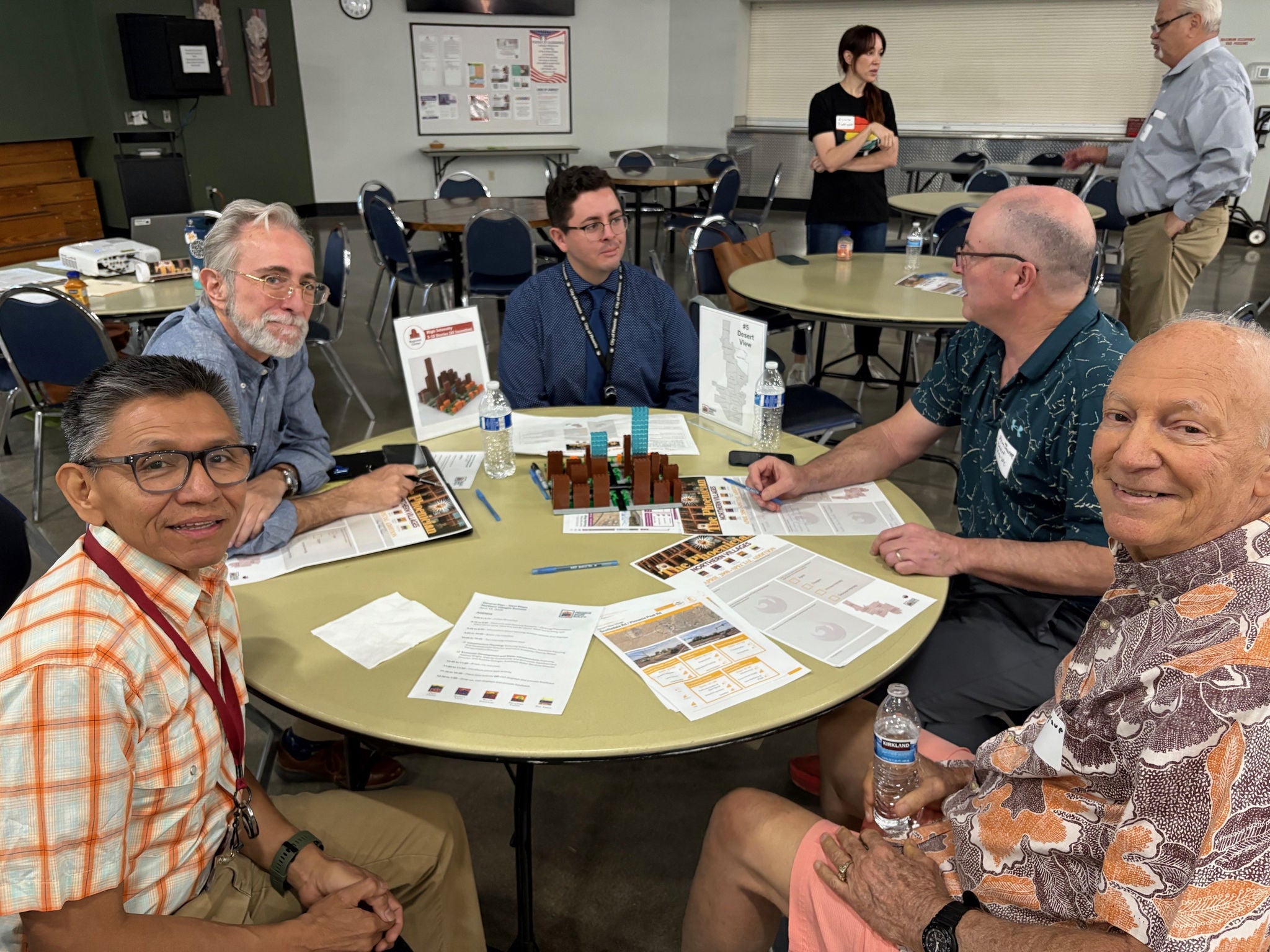 5 male residents sit at a round table and discuss the intensity of development of a transect district
