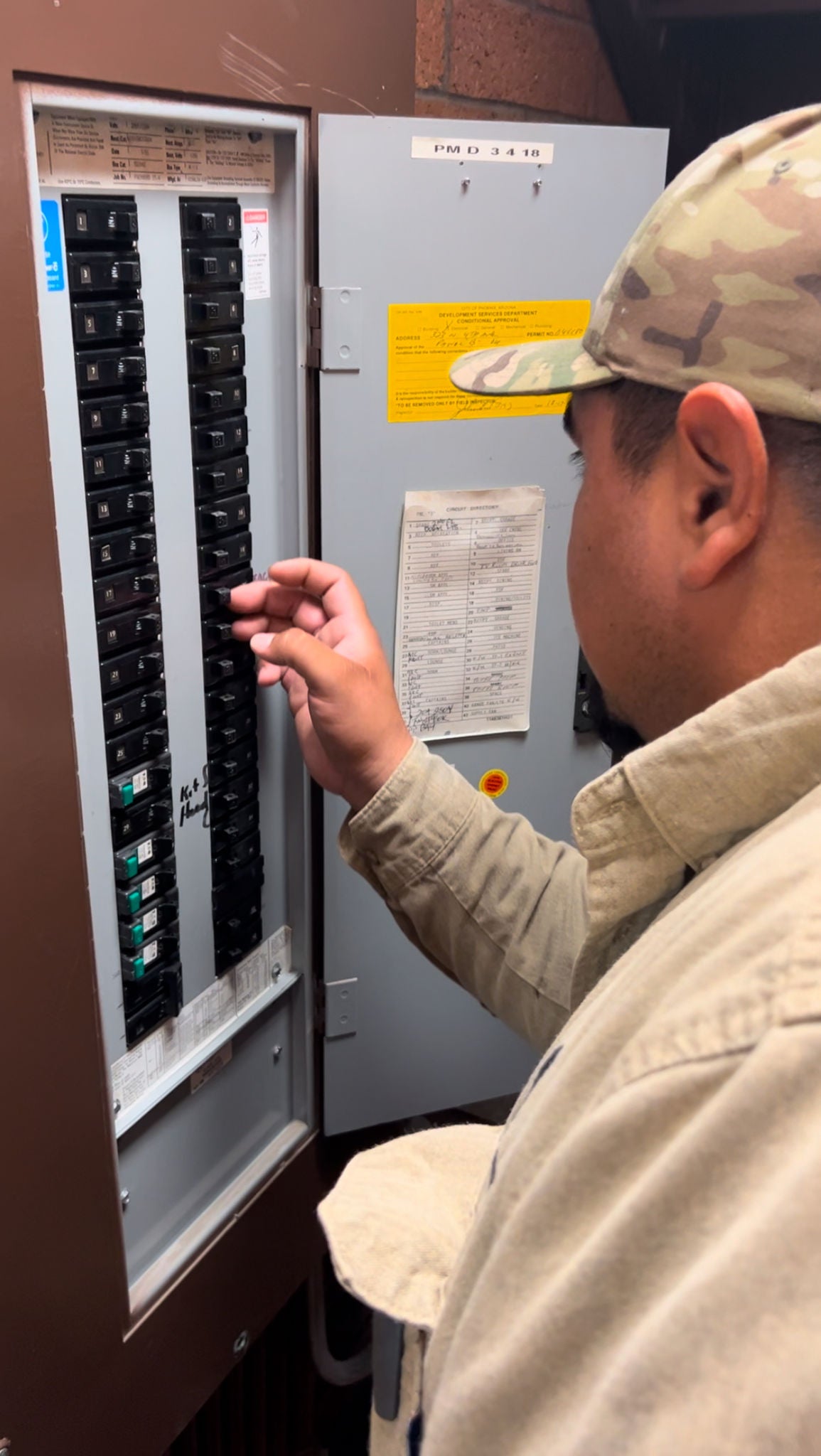 An electrician checks switches in a circuit breaker.