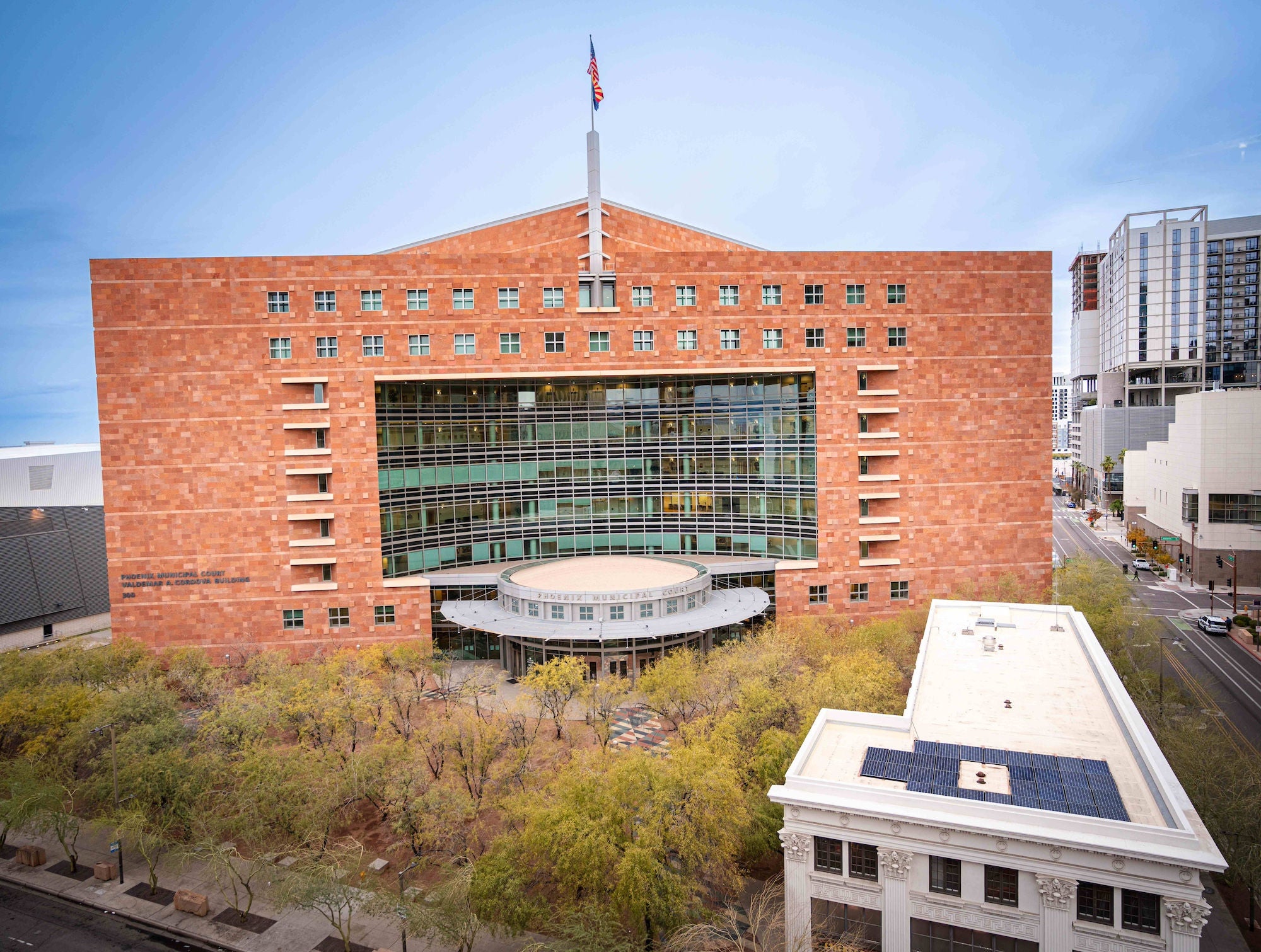 Phoenix Municipal Court. It is a large brick building with a semi-circle of glass windows in the middle. An American flag waves from the upper middle part of the building.