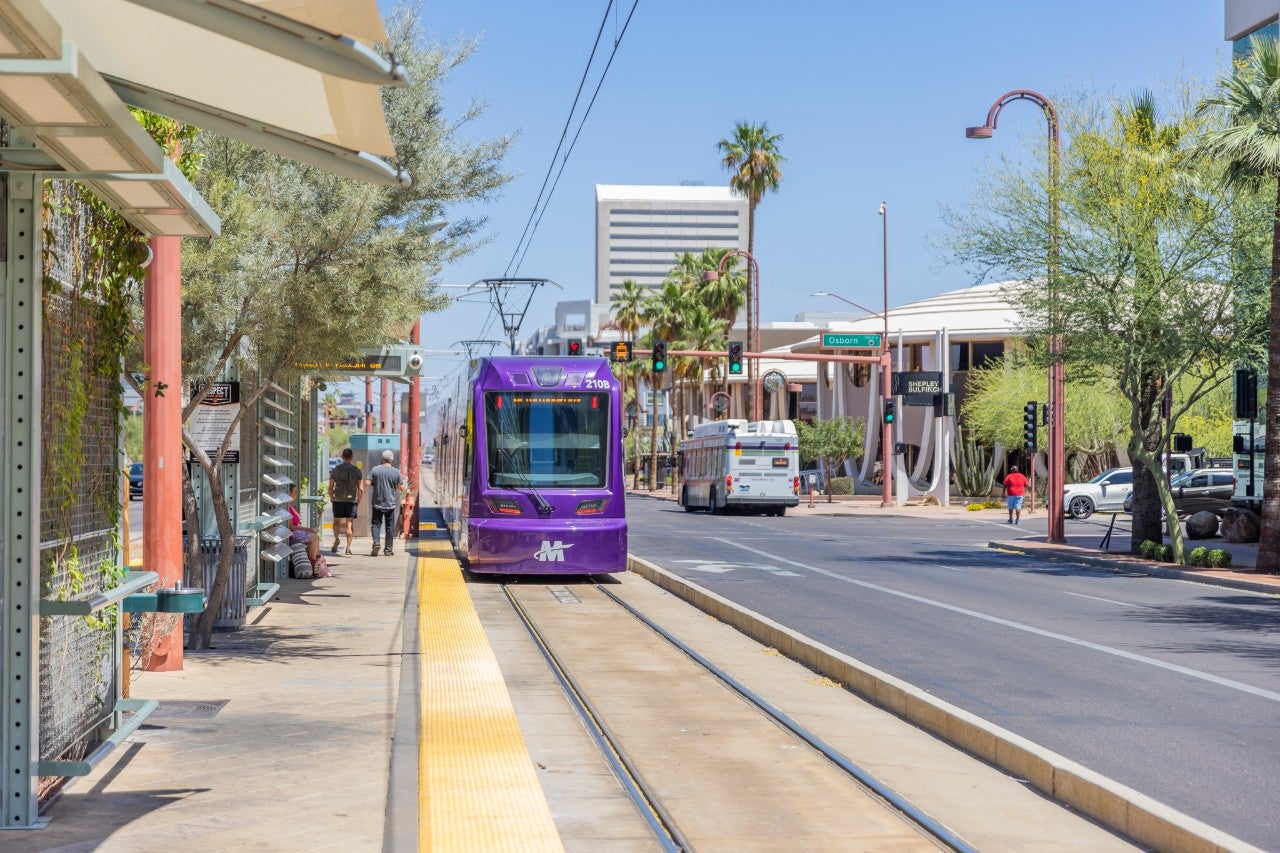 <p>A Valley Metro purple light rail train departing a station in downtown Phoenix.</p>