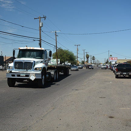 Truck and other cars on an unmarked road.