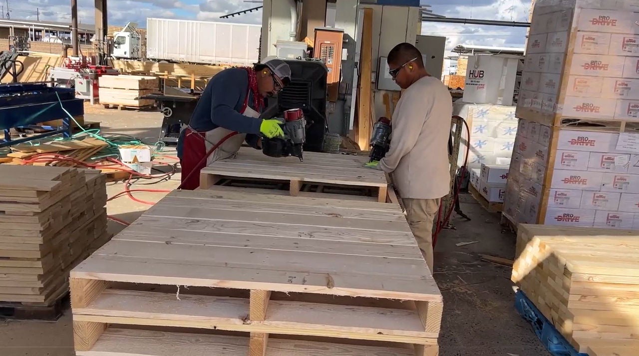 Two Moran Lumber employees assembling a wood pallet.
