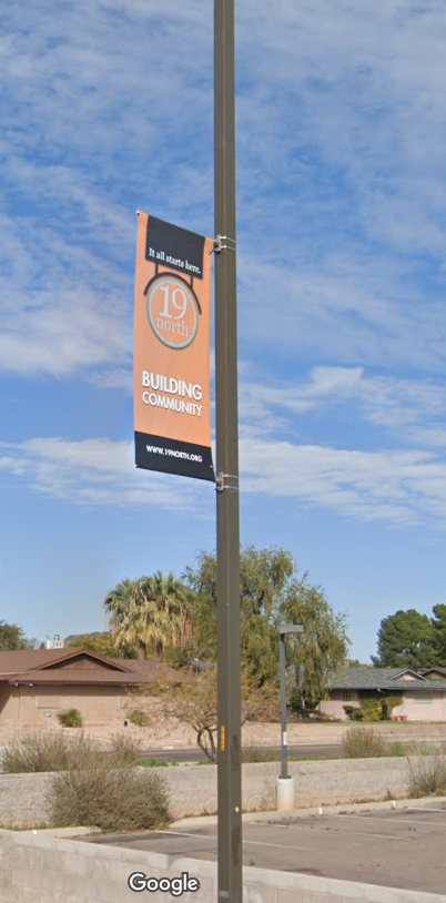 Image of a City of Phoenix light pole with brackets holding a decorative banner